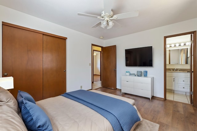 bedroom with a closet, dark hardwood / wood-style flooring, connected bathroom, and ceiling fan