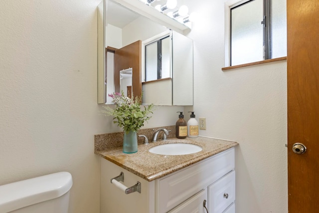 bathroom with toilet and vanity