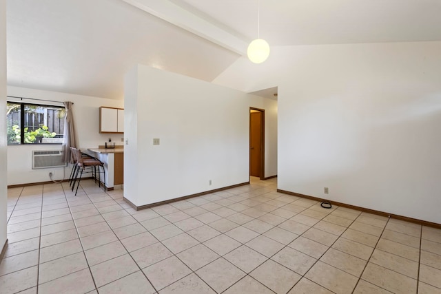 empty room with light tile patterned floors, lofted ceiling with beams, and a wall mounted AC