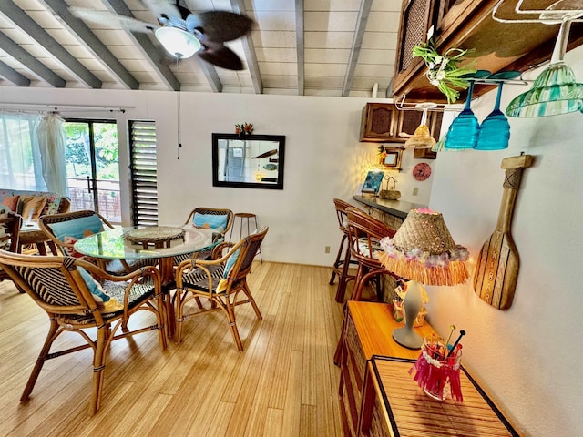 dining room with vaulted ceiling with beams, light hardwood / wood-style flooring, and ceiling fan