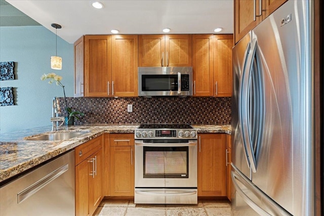 kitchen featuring decorative backsplash, stainless steel appliances, sink, decorative light fixtures, and stone counters