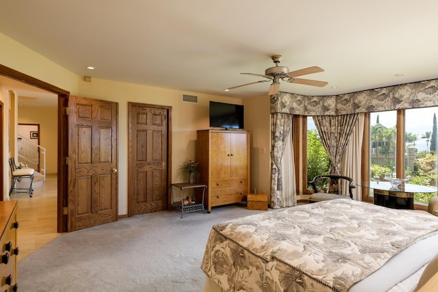 bedroom with ceiling fan and light colored carpet