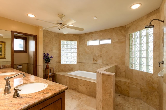 bathroom with double sink vanity, tile floors, ceiling fan, and tiled bath