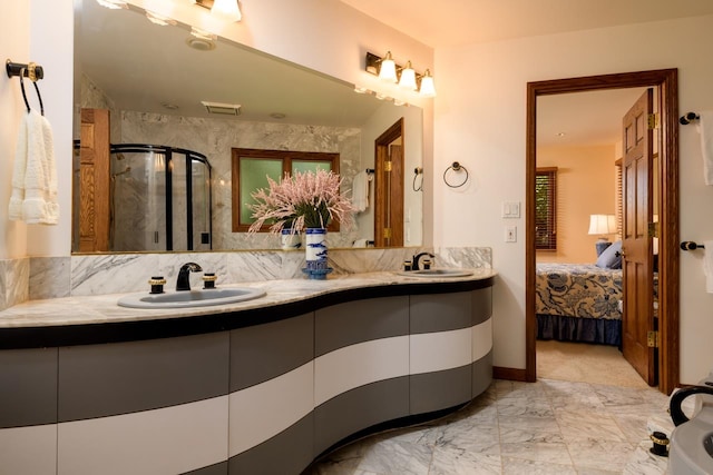 bathroom featuring a shower with shower door, oversized vanity, double sink, tasteful backsplash, and tile flooring