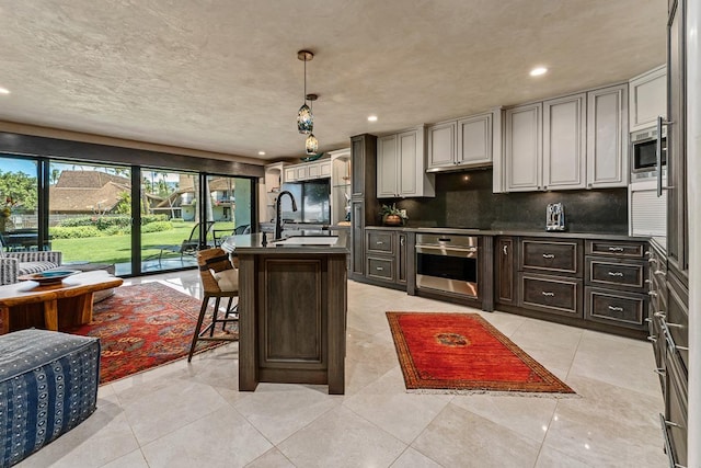 12 S Kihei Rd Unit E2, Kihei, HI 96753 - kitchen featuring stainless steel appliances, backsplash, dark countertops, recessed lighting, and a kitchen bar