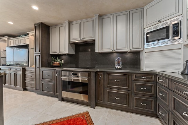 12 S Kihei Rd Unit E2, Kihei, HI 96753 - kitchen with stainless steel appliances, light tile patterned floors, recessed lighting, decorative backsplash, and dark brown cabinetry