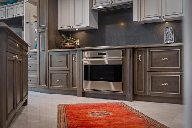 12 S Kihei Rd Unit E2, Kihei, HI 96753 - kitchen featuring stainless steel oven, decorative backsplash, light tile patterned floors, and under cabinet range hood