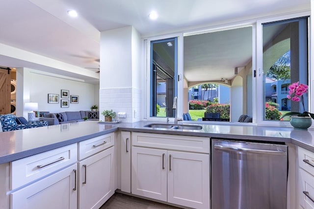 kitchen with dishwasher, white cabinetry, sink, and kitchen peninsula