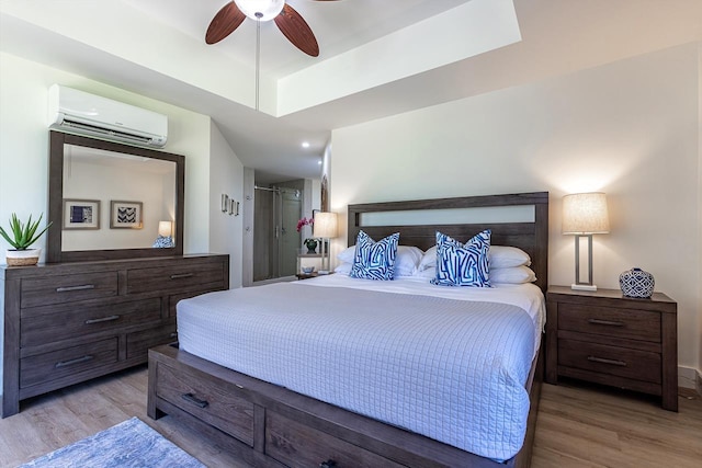 bedroom featuring a wall mounted air conditioner, ceiling fan, and hardwood / wood-style flooring