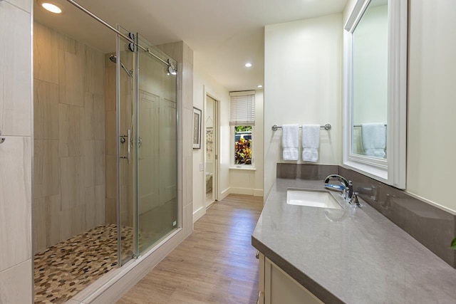 bathroom with walk in shower, hardwood / wood-style floors, vanity, and toilet