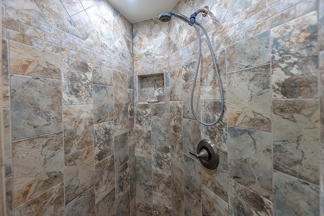 interior details featuring a tile shower