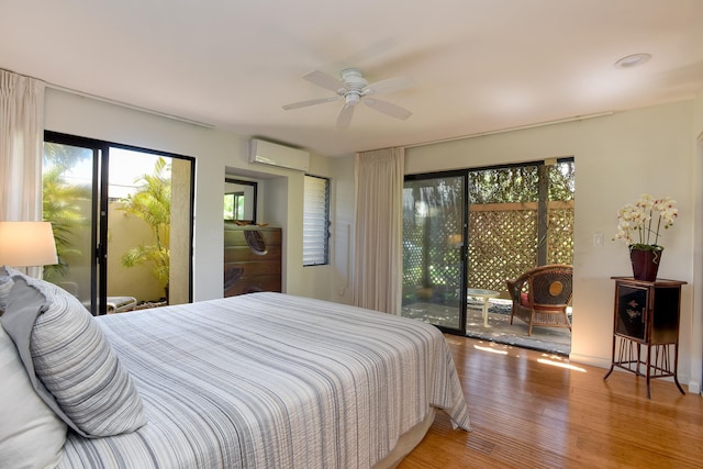 bedroom with ceiling fan, hardwood / wood-style floors, a wall unit AC, and access to outside