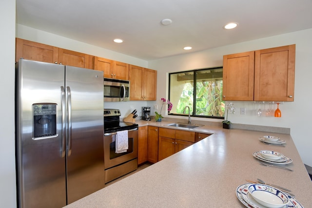 kitchen featuring appliances with stainless steel finishes, kitchen peninsula, and sink