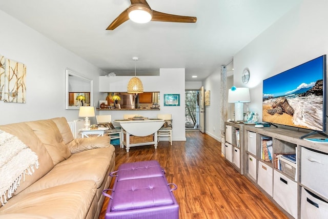 living room featuring ceiling fan and dark hardwood / wood-style floors