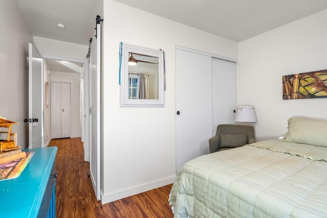 bedroom with dark hardwood / wood-style flooring and a closet