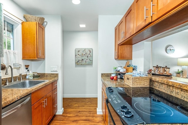 kitchen with dark hardwood / wood-style flooring, sink, stone counters, dishwasher, and range