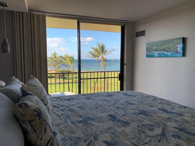 bedroom featuring access to exterior, expansive windows, and a water view