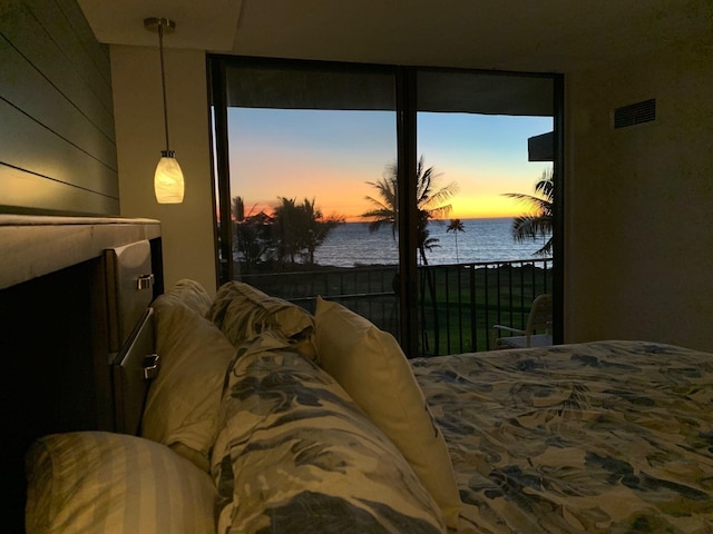 bedroom featuring a water view and wood walls