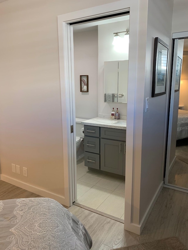 bathroom featuring vanity, toilet, and wood-type flooring