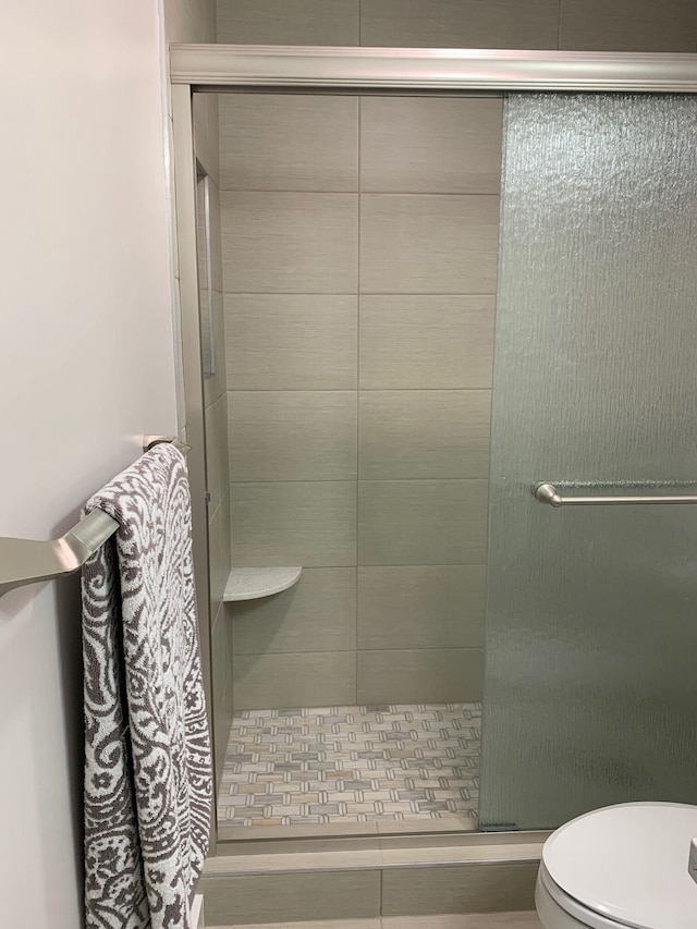 bathroom featuring toilet and walk in shower