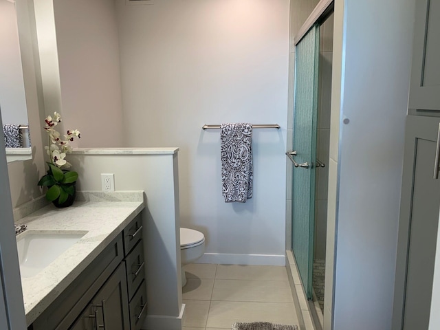 bathroom with tile patterned floors, vanity, an enclosed shower, and toilet