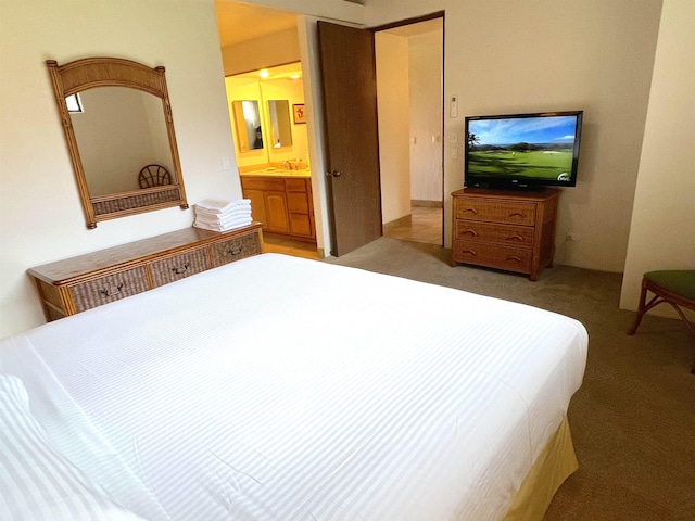 bedroom featuring light colored carpet, ensuite bathroom, and a sink