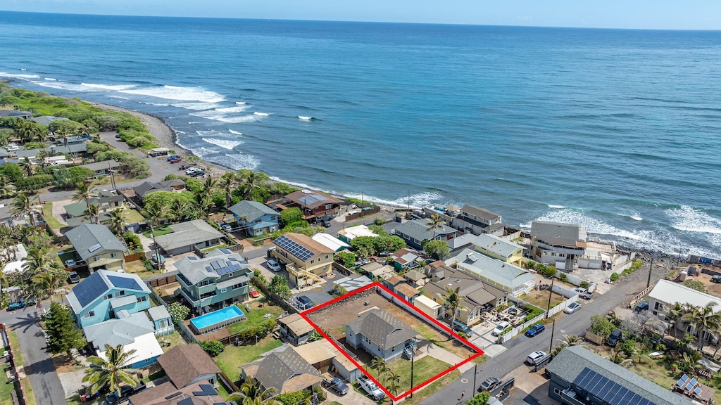 drone / aerial view with a residential view, a beach view, and a water view
