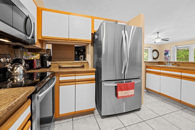 kitchen featuring white cabinets, sink, appliances with stainless steel finishes, and light tile patterned floors