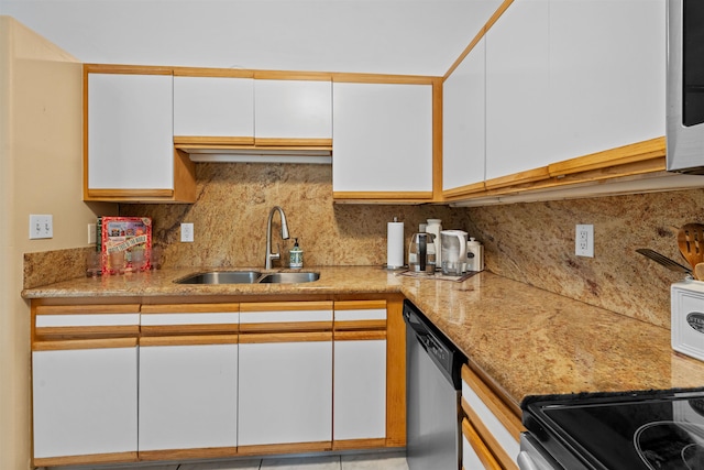 kitchen featuring tasteful backsplash, sink, white cabinetry, light stone countertops, and stainless steel dishwasher