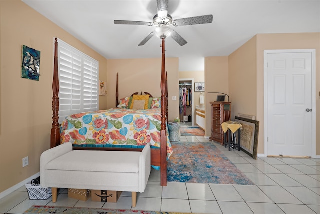 tiled bedroom featuring a closet, ceiling fan, and a walk in closet