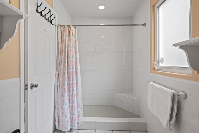 bathroom with a shower with curtain and tile walls