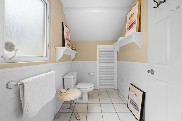 bathroom with tile walls, vaulted ceiling, tile patterned floors, and toilet