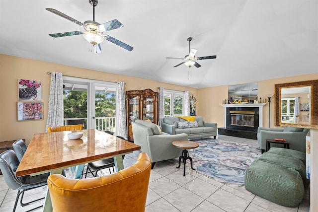 living room featuring french doors, ceiling fan, a fireplace, and light tile patterned floors