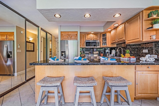 kitchen with a breakfast bar area, stainless steel appliances, and kitchen peninsula