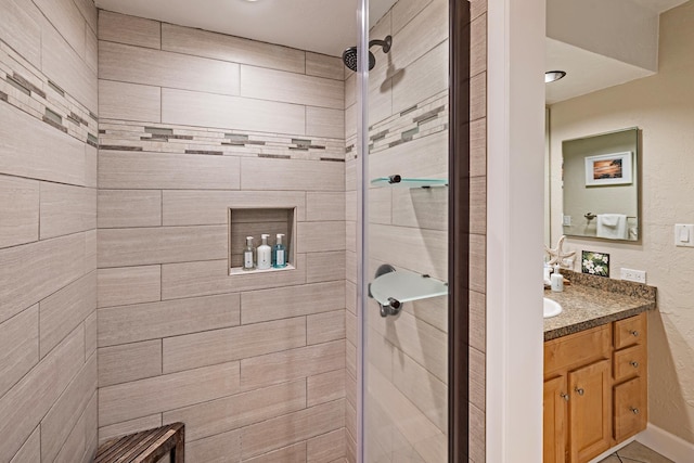 bathroom featuring vanity and tiled shower