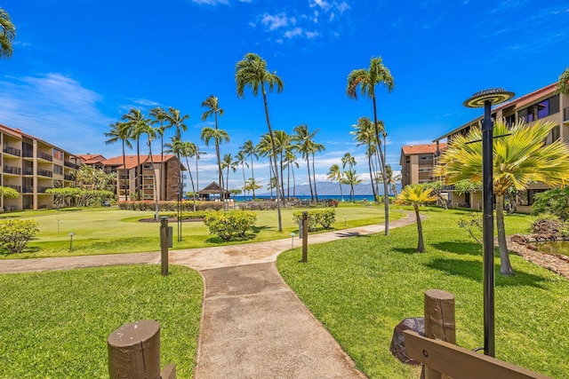 view of home's community featuring a lawn and a water view