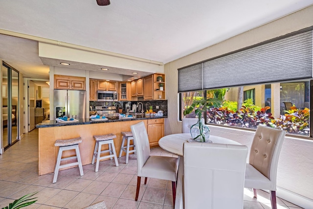 dining space featuring sink and light tile patterned floors