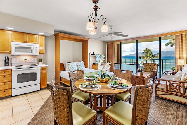 tiled dining area featuring ceiling fan with notable chandelier