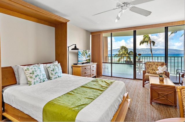 bedroom featuring access to exterior, a wall of windows, and ceiling fan