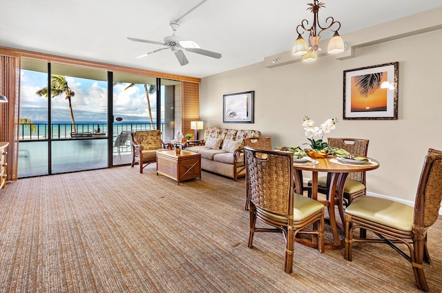 living room featuring a water view, light colored carpet, and ceiling fan with notable chandelier