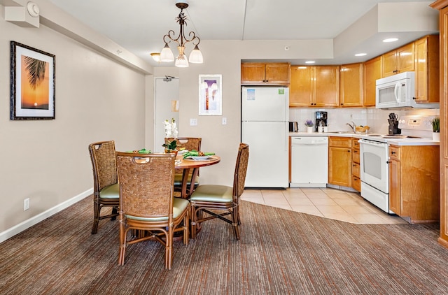 kitchen featuring sink, light tile patterned floors, decorative light fixtures, backsplash, and white appliances