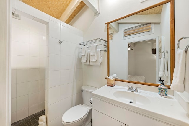 bathroom with vanity, toilet, and a tile shower