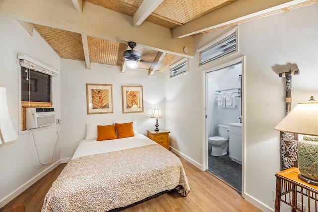 bedroom featuring beamed ceiling, hardwood / wood-style floors, ensuite bath, cooling unit, and ceiling fan