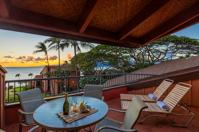 deck at dusk featuring a water view