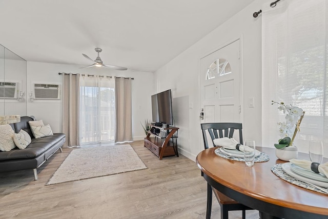 living room with ceiling fan, light hardwood / wood-style flooring, and a wall mounted air conditioner