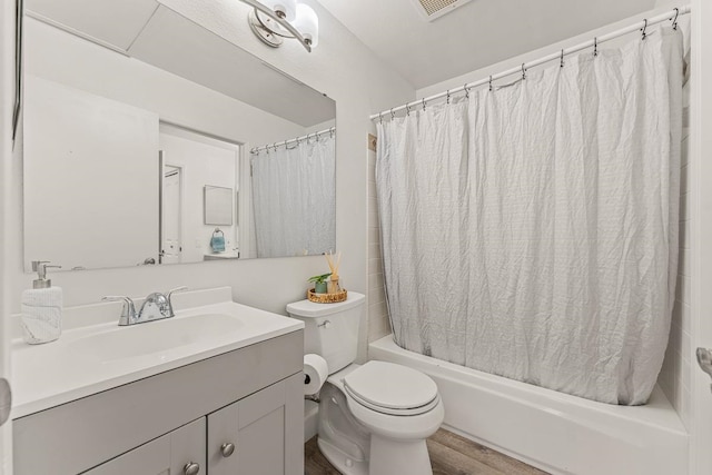 full bathroom with shower / bathtub combination with curtain, hardwood / wood-style floors, vanity, and toilet