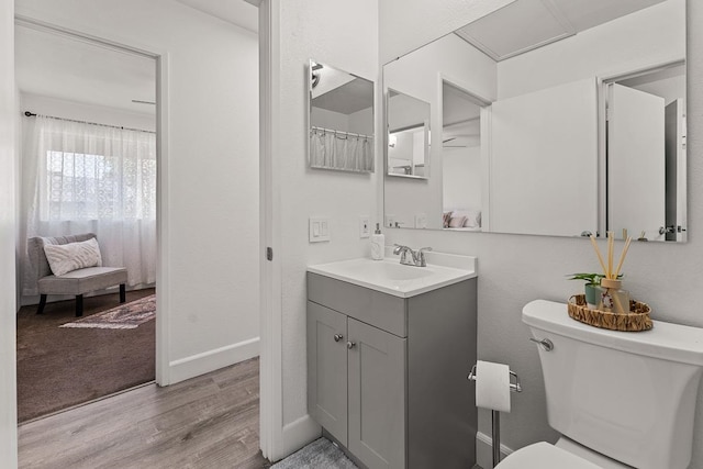 bathroom featuring wood-type flooring, vanity, and toilet