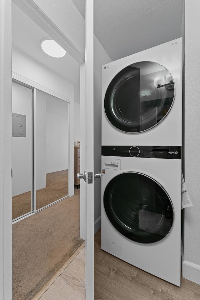 washroom featuring stacked washing maching and dryer and hardwood / wood-style flooring