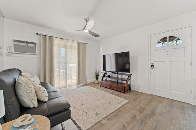 living room featuring light hardwood / wood-style floors, ceiling fan, and a wall mounted AC