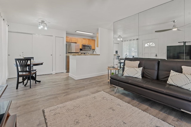 living room featuring light wood-type flooring and ceiling fan